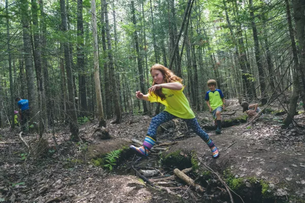 Youth running and playing in the woods