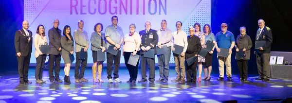 A line of volunteers smiling on stage