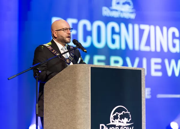 The mayor standing at a podium speaking