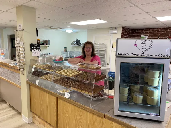 Janet behind a case of baked goods