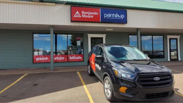 Branded car Infront of the Paint Shop building with signage. 