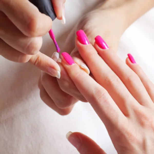 Nail technician applying salon nails to client.