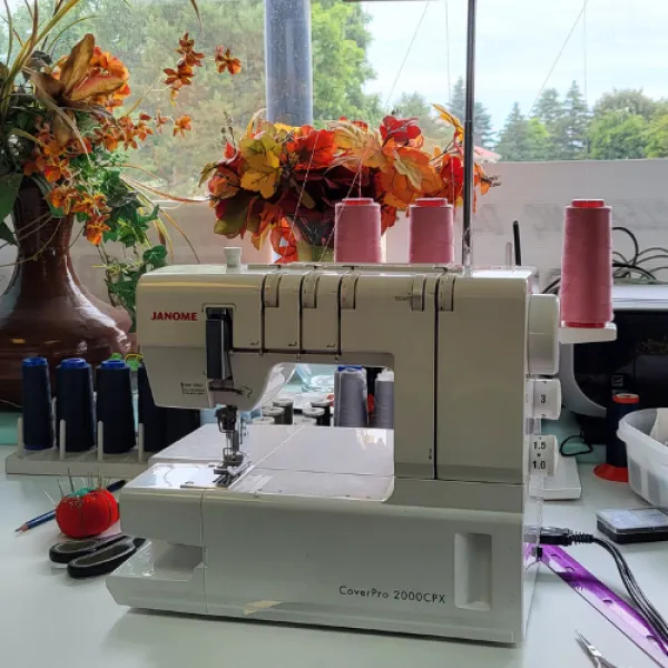 Interior of Unique Sewing Solutions. Sewing machine on the counter and flowers. 