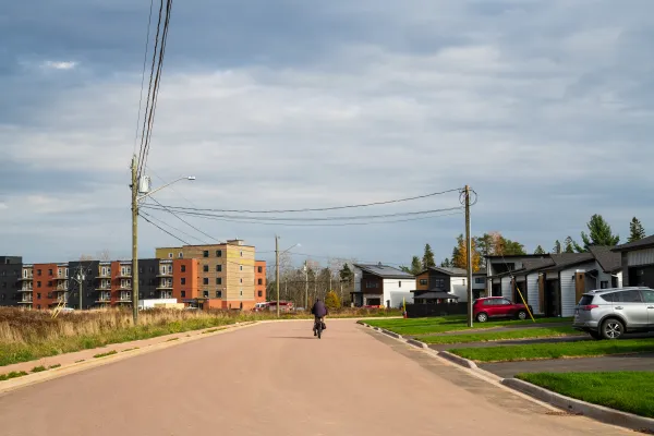 man bikes down street alongside semi detached houses