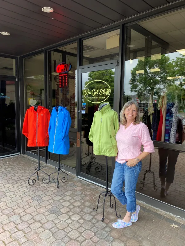 Store owner standing outside storefront smiling 