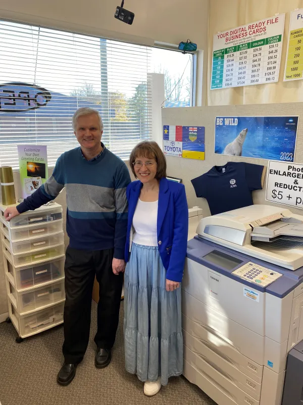 Store owners standing in their print shop smiling