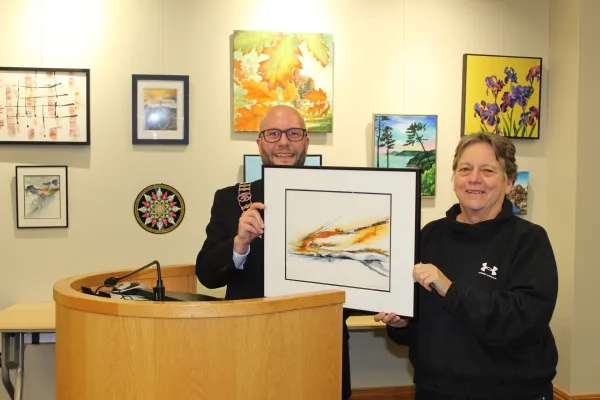 Artist standing with Mayor holding artwork and smiling