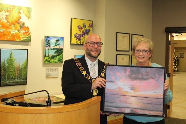 Mayor and artist holding artwork and smiling