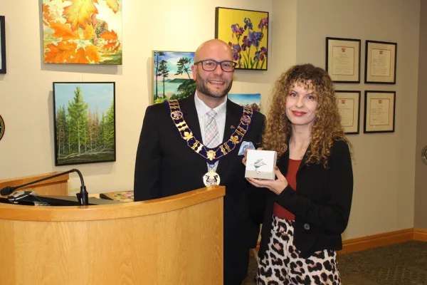 Artist and Mayor holding artwork and smiling