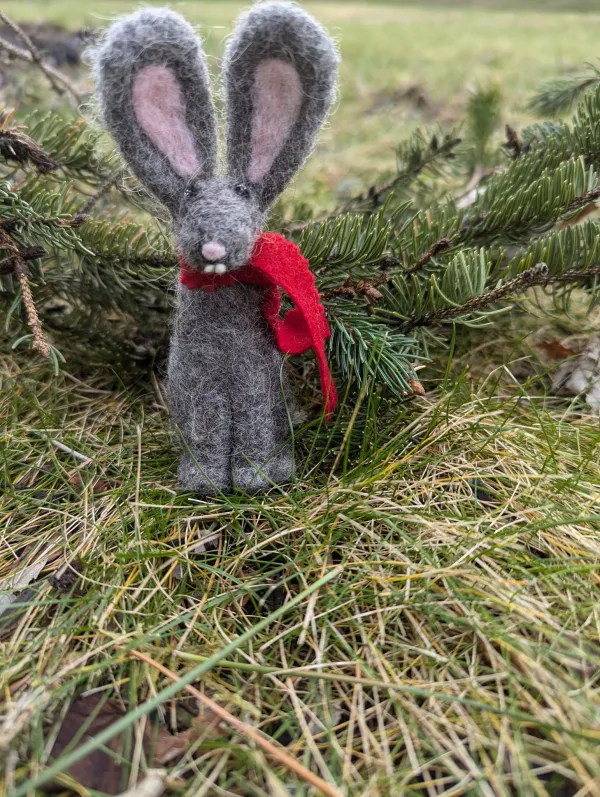 Needle felted winter bunny in the grass.