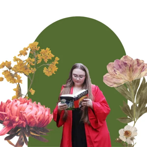 A girl reading a book with a floral and green backdrop