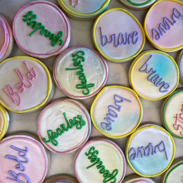 Cookies decorated with empowering adjectives like "brave" and "fearless"