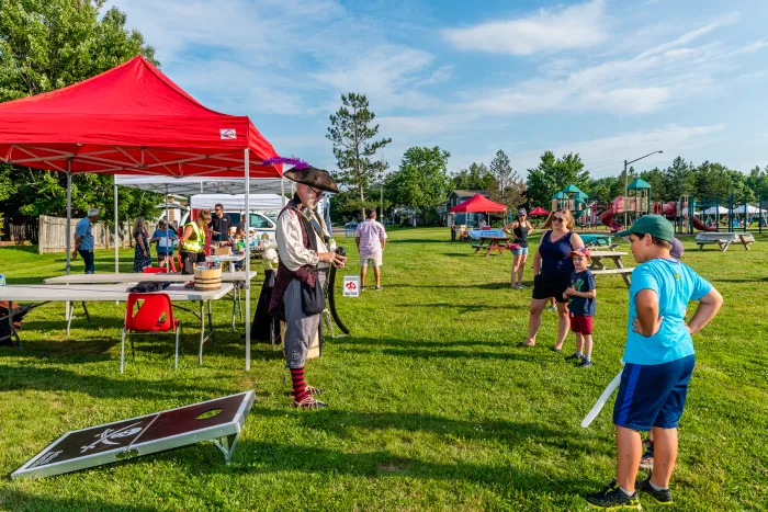 Vendors set up outside at a park with kids playing